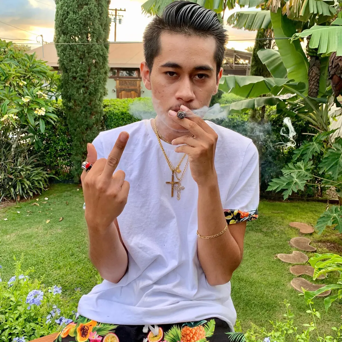 John Caicedo in a white tee in a tropical garden